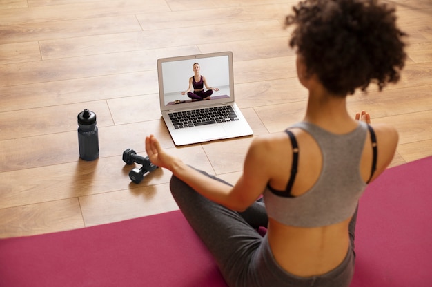 Mujer de tiro medio haciendo ejercicio con laptop