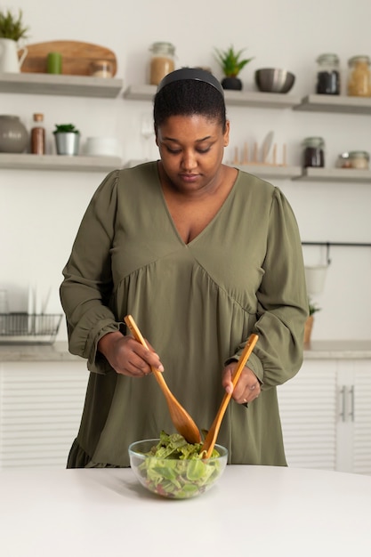 Mujer de tiro medio haciendo ensalada