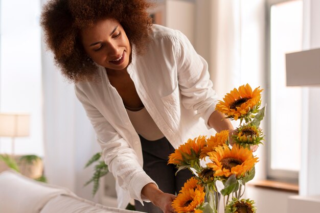 Mujer de tiro medio con hermosos girasoles.