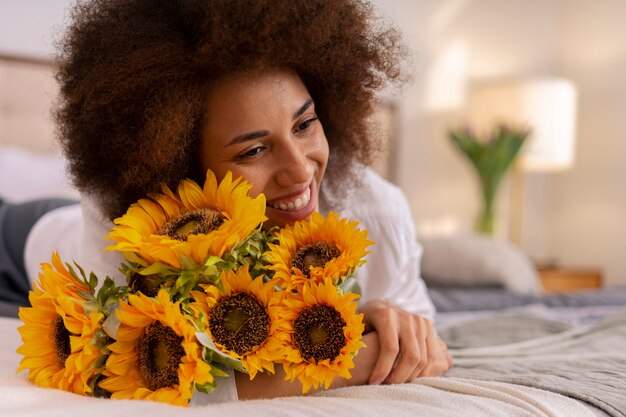 Mujer de tiro medio con hermosos girasoles.