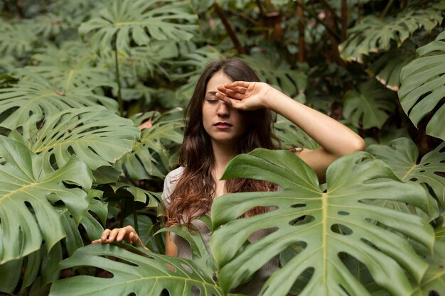 Mujer de tiro medio con hojas de monstera