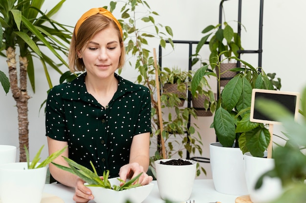 Mujer de tiro medio jardinería interior