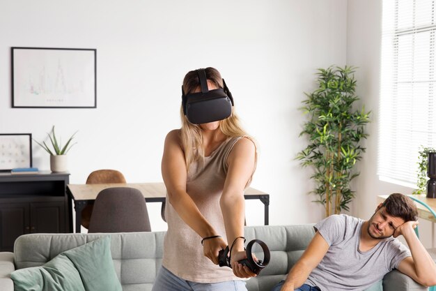 Mujer de tiro medio jugando con gafas vr