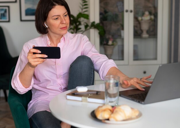 Foto gratuita mujer de tiro medio jugando con su teléfono