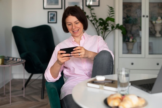 Mujer de tiro medio jugando con su teléfono