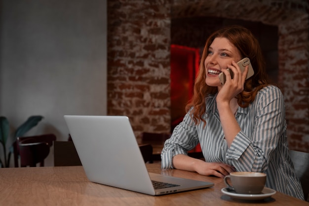 Foto gratuita mujer de tiro medio con laptop en cafetería