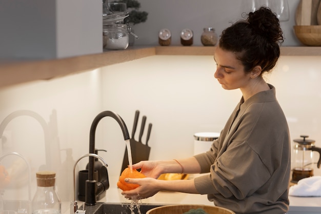 Mujer de tiro medio lavando pimiento