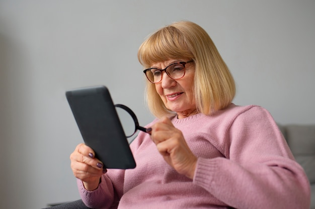 Mujer de tiro medio con lector de libros electrónicos