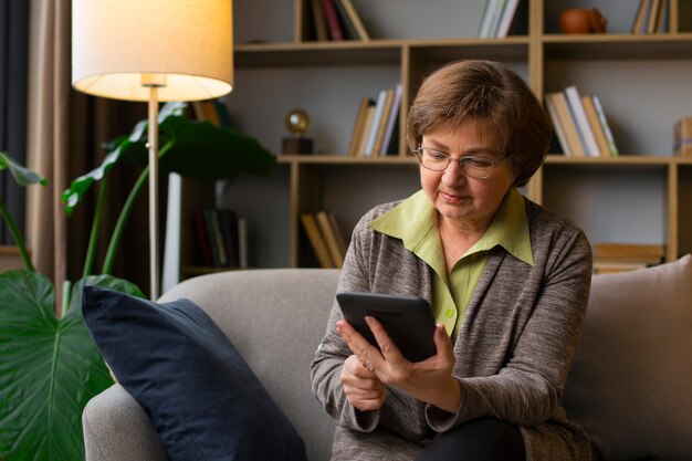 Mujer de tiro medio con lector de libros electrónicos