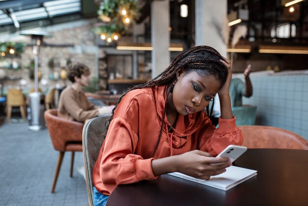 Mujer de tiro medio leyendo en la cafetería