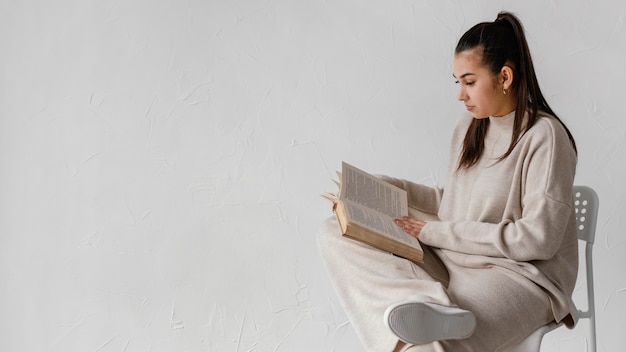 Mujer de tiro medio leyendo con espacio de copia