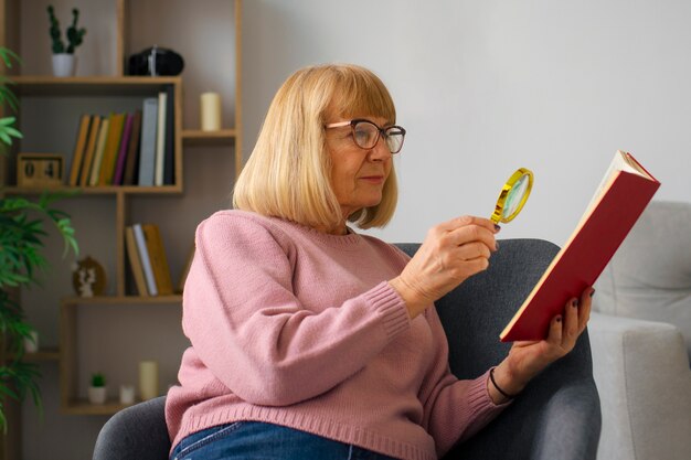 Mujer de tiro medio leyendo con lupa