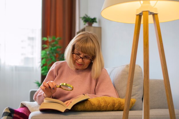 Mujer de tiro medio leyendo con lupa