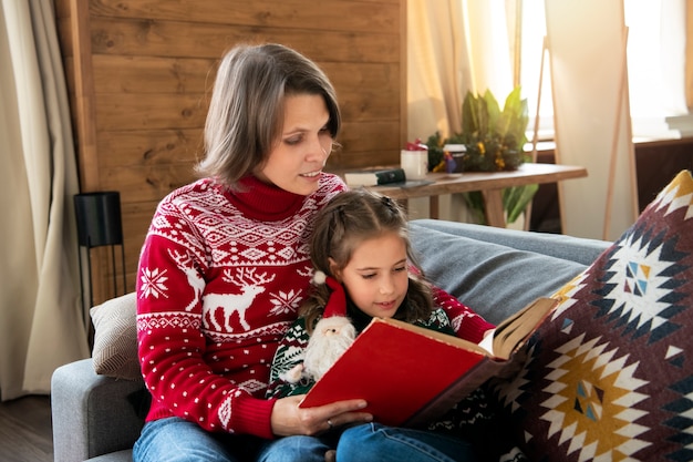 Mujer de tiro medio leyendo a niña