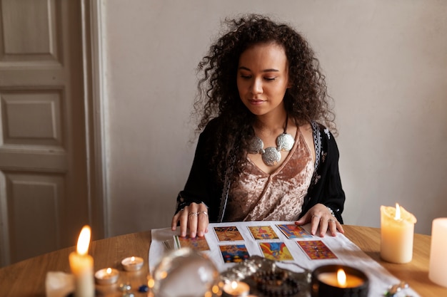 Mujer de tiro medio leyendo tarot en casa