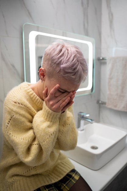 Mujer de tiro medio llorando en el baño.