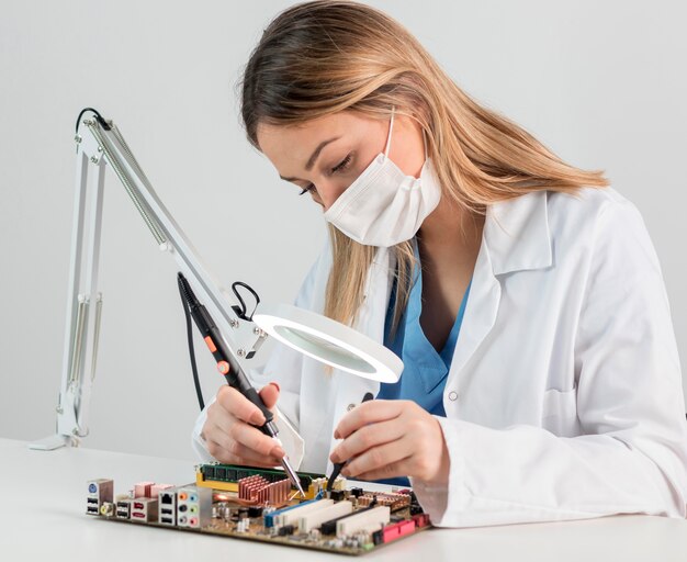 Mujer de tiro medio con mascarilla trabajando