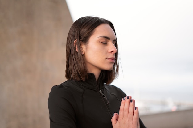 Mujer de tiro medio meditando afuera