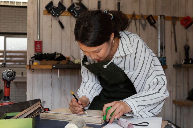 Mujer de tiro medio midiendo madera