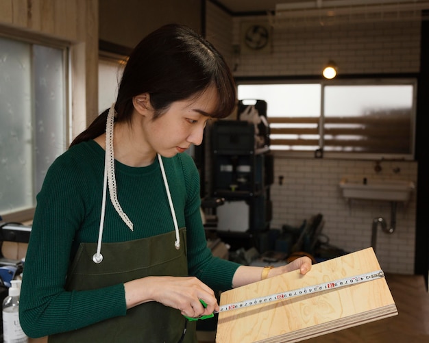 Foto gratuita mujer de tiro medio midiendo madera