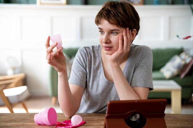 Mujer de tiro medio mirando la copa menstrual