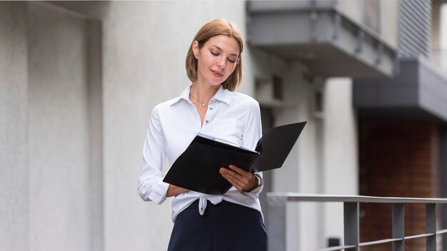 Mujer de tiro medio mirando documentos