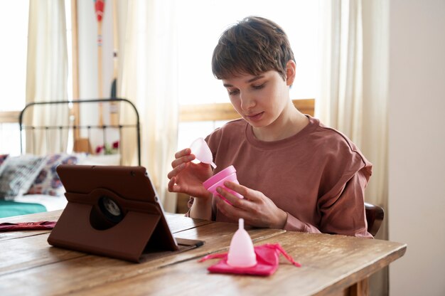 Mujer de tiro medio mirando producto menstrual.