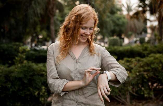 Mujer de tiro medio mirando smartwatch