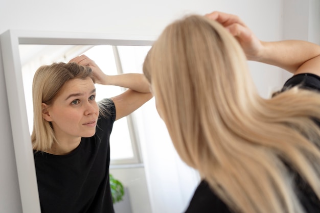 Foto gratuita mujer de tiro medio mirándose en el espejo