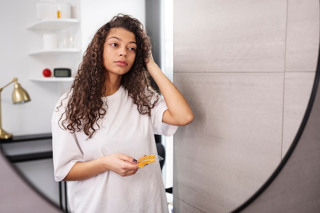 Foto gratuita mujer de tiro medio mirándose en el espejo