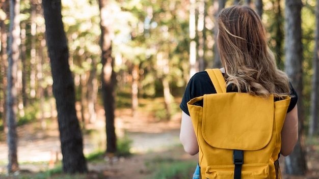 Mujer de tiro medio con mochila en el bosque