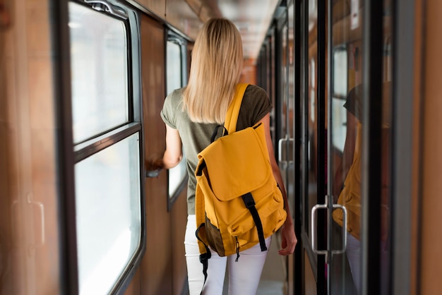 Mujer de tiro medio con mochila en tren