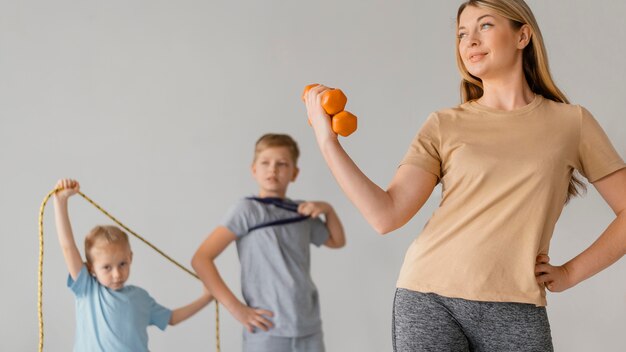 Mujer de tiro medio y niños haciendo ejercicio