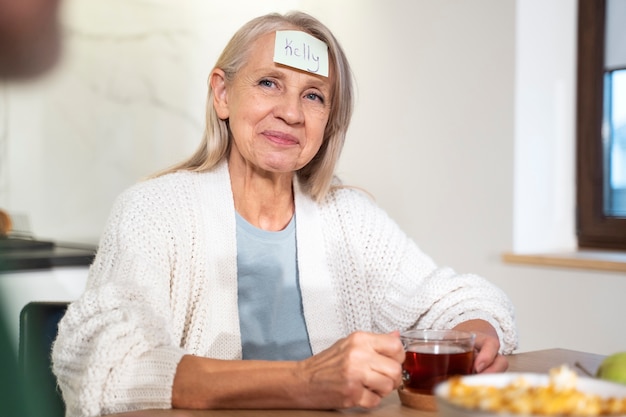 Foto gratuita mujer de tiro medio con nota en la frente