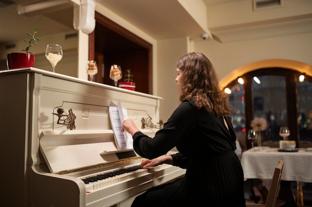 Mujer de tiro medio con partitura de piano.