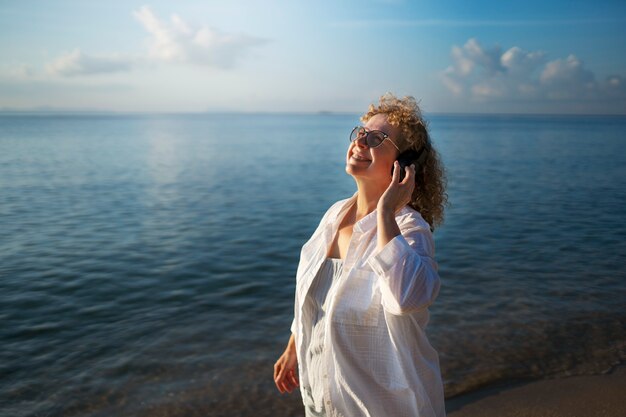 Mujer de tiro medio pasando un día sola en la playa.