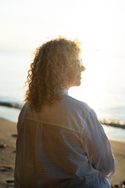 Mujer de tiro medio pasando un día sola en la playa.