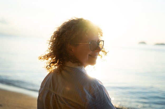 Mujer de tiro medio pasando un día sola en la playa.