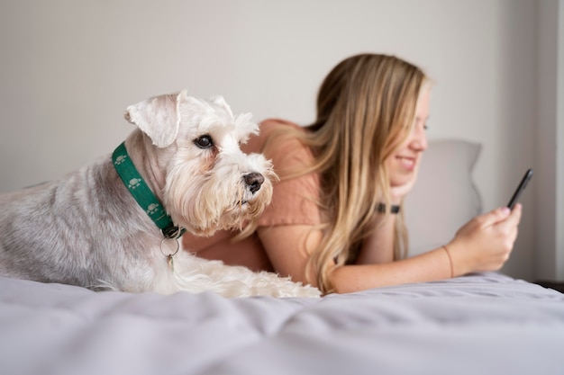 Mujer de tiro medio y perro en la cama