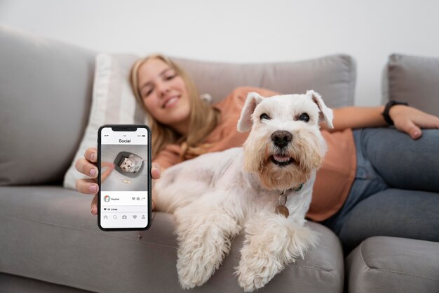 Mujer de tiro medio y perro con teléfono