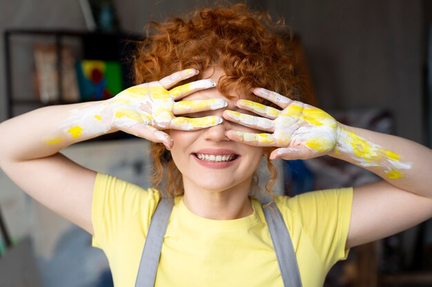 Mujer de tiro medio con pintura amarilla