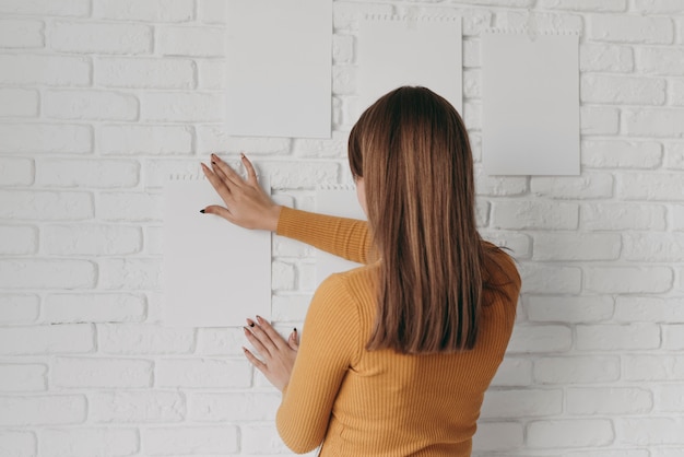 Mujer de tiro medio poniendo papel en la pared