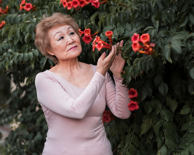 Mujer de tiro medio posando con bonitas flores