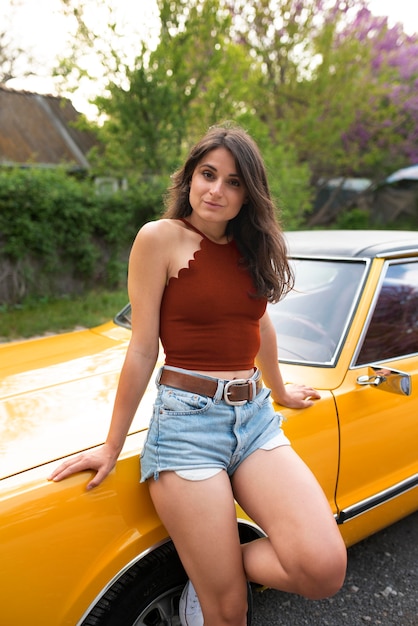 Mujer de tiro medio posando con coche