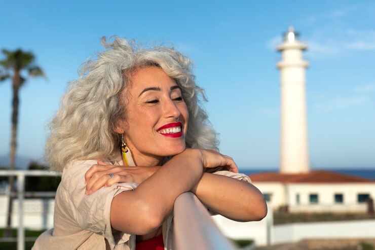 Mujer de tiro medio posando en el faro.