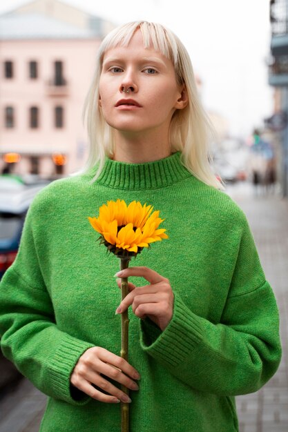 Mujer de tiro medio posando con flor