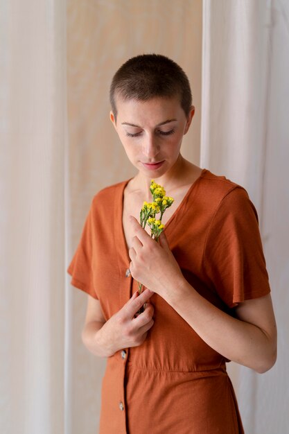 Mujer de tiro medio posando con flores