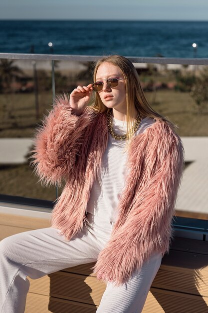 Mujer de tiro medio posando con gafas de sol