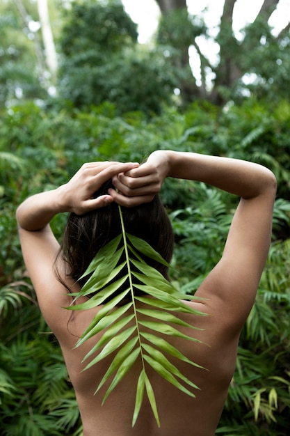 Mujer de tiro medio posando con hoja