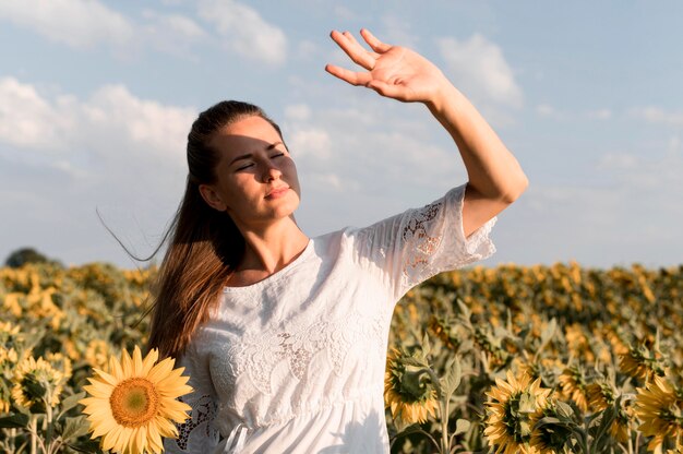 Mujer de tiro medio posando en la luz del sol